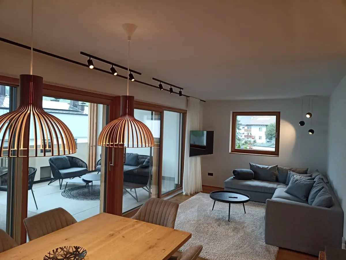 Zona giorno con lampade in legno, tavolo da pranzo e vista sulla terrazza
